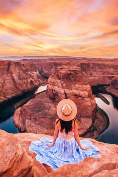 a woman sitting on top of a large rock next to a river in the desert