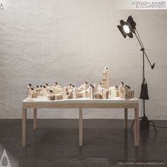 a table that has some kind of model on it with a lamp next to it