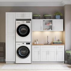 a washer and dryer sitting in a room with white cupboards on the wall