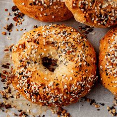 bagels with sesame seeds and poppy seed sprinkles on a piece of parchment paper