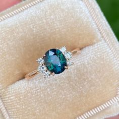 a close up of a person holding a ring with a blue and white stone in it