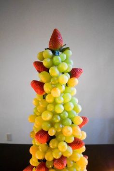 a fruit christmas tree made out of grapes and strawberries