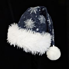 a blue hat with white snowflakes and a pom - pom on it