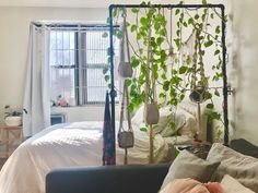 a bed with plants growing on the headboard and hanging from it's sides