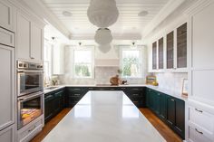 a kitchen with white counter tops and black cabinets