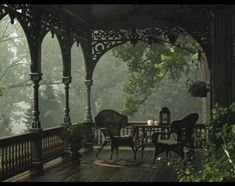 an outdoor dining area with chairs and tables in the foggy forest, surrounded by greenery