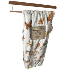 a baby swaddle hanging from a wooden hanger with an animal print on it