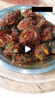 a glass plate filled with fried vegetables on top of a wooden table