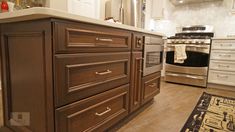 a kitchen with wooden cabinets and stainless steel stove top oven in the center, next to an area rug on the floor