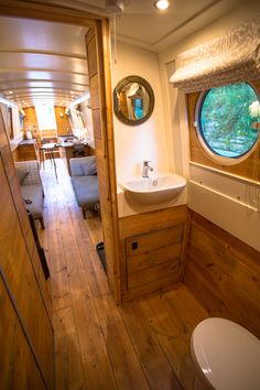 there is a small bathroom with wood flooring in this boat's cabin room