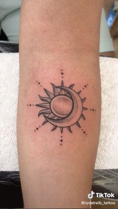 a small sun and moon tattoo on the leg