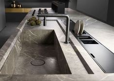 a modern kitchen with marble counter tops and stainless steel faucets