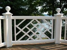 an outdoor deck with white railing and wood flooring