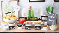 a table topped with bowls filled with food next to a sign that says hello baby