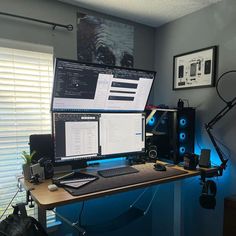 a computer desk with two monitors and speakers