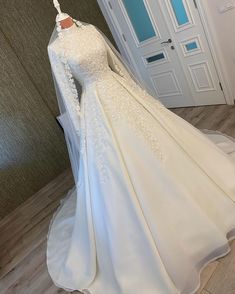 a white wedding gown on display in front of a door