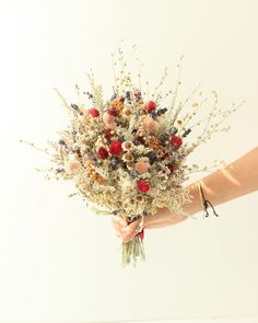 a person holding a bouquet of flowers in their hand