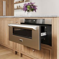 an oven built into the side of a wooden cabinet in a kitchen with stainless steel appliances