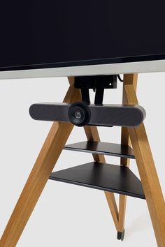 an electronic device is sitting on top of a wooden stand with two speakers attached to it