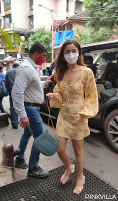 a woman wearing a face mask walking down the street