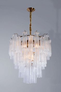 a chandelier hanging from the ceiling with many glass pieces on top of it