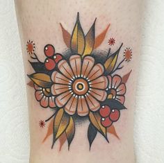 a close up of a flower tattoo on the leg