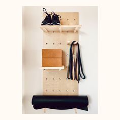 a pair of shoes is hanging on a wall mounted shelf with hooks and shoelaces