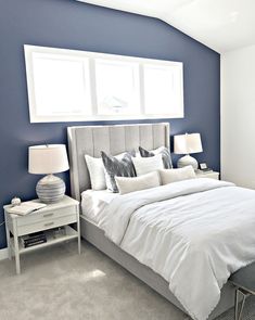 a bedroom with blue walls and white bedding