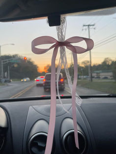 a pink ribbon tied to the dashboard of a car