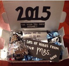 an open box with some candy and congratulations messages in it's wrapper, on top of a wooden table