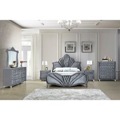 a bedroom scene with focus on the bed, dressers and nightstands that are decorated in silver