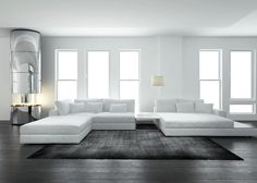 a large white couch sitting on top of a hard wood floored living room filled with furniture