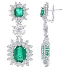 Burst out in style with this gorgeous pair of 18k white gold earrings. Showcases 4 fancy emerald cut emeralds weighing 15.67 carats surrounded by sparkling round diamonds in a creative floral motif. Suspended on vibrant radiant cut emeralds surrounded by brilliant diamonds as well. White diamonds weigh 10.23 carats total. Style available in different price ranges. Prices are based on your selection. Please contact us for more information. Style available in different price ranges. Prices are bas Long Diamond Earrings, Halo Diamond Earrings, Flower Dangle Earrings, Fancy Yellow Diamond, Halo Earrings, Diamond Dangle Earrings, White Gold Earrings, Emerald Earrings, Oval Cut Diamond