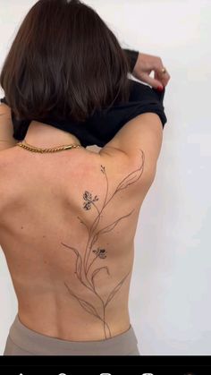 the back of a woman's body with tattoos on it