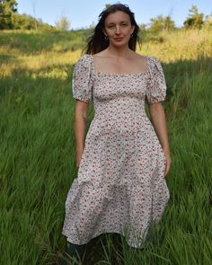 Lipstick Red Mini Roses on White Cotton Prairie Dress, Smocked Bodice, Puffed Sleeves, Midi Length, with Pockets Product Details: Elevate your style with our Lipstick Red Mini Roses on White Cotton Prairie Dress. This enchanting dress features a crisp white backdrop adorned with vibrant red mini roses, creating a beautiful and eye-catching contrast. The smocked bodice ensures a comfortable, adjustable fit, while the puffed sleeves and flowy midi skirt enhance its classic prairie charm. With the addition of practical side pockets, this dress blends timeless elegance with modern convenience. Perfect for a variety of occasions, from summer outings to special events, this dress pairs effortlessly with sandals or boots. Add a light jacket or cardigan to transition through the seasons with ease. Fitted Vintage Smocked Dress For Summer, Fitted Smocked Dress With Smocked Cuffs For Garden Party, Floral Print Fitted Smocked Dress With Puff Sleeves, Fitted Smocked Dress With Floral Print And Puff Sleeves, Fitted Smocked Dress With Puff Sleeves And Floral Print, Red Fitted Smocked Dress With Ruched Detail, Fitted Prairie Dress With Smocked Bodice For Summer, Fitted Red Smocked Dress With Ruched Details, Fitted Smock Prairie Dress For Daywear