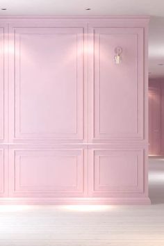 an empty room with pink walls and white floors