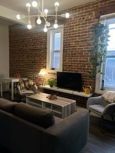 a living room filled with furniture and a flat screen tv sitting on top of a wooden table