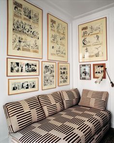 a living room filled with lots of pictures and art on the wall next to a couch