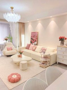 a living room filled with white furniture and pink accents