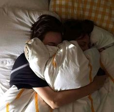 two women laying in bed hugging each other