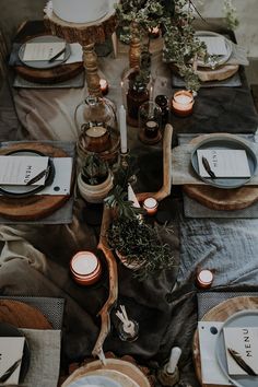 the table is set with candles, plates and napkins for dinner guests to enjoy