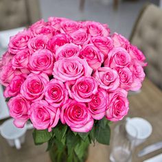 a vase filled with pink roses on top of a table