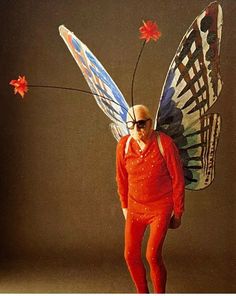 a man dressed as a butterfly with red pants and sunglasses