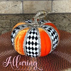 an orange and black pumpkin sitting on top of a table