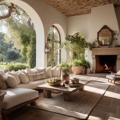 a living room filled with furniture and a fire place in the middle of an open floor plan