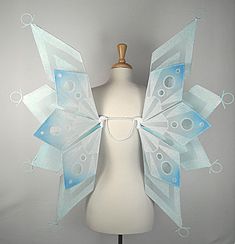 a white mannequin with blue wings on it