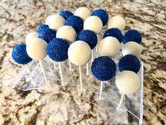 blue and white cake pops on a clear stand