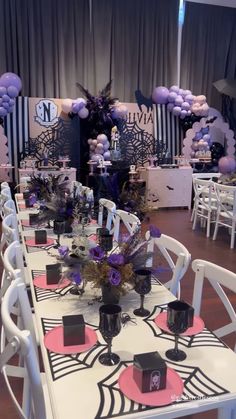 tables and chairs set up for a party with purple, black and white decorations on them