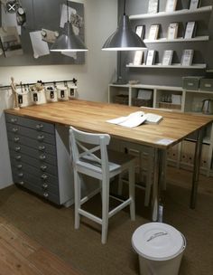 a desk with several drawers and two chairs