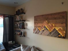 a living room with a white couch and wooden wall art on it's walls